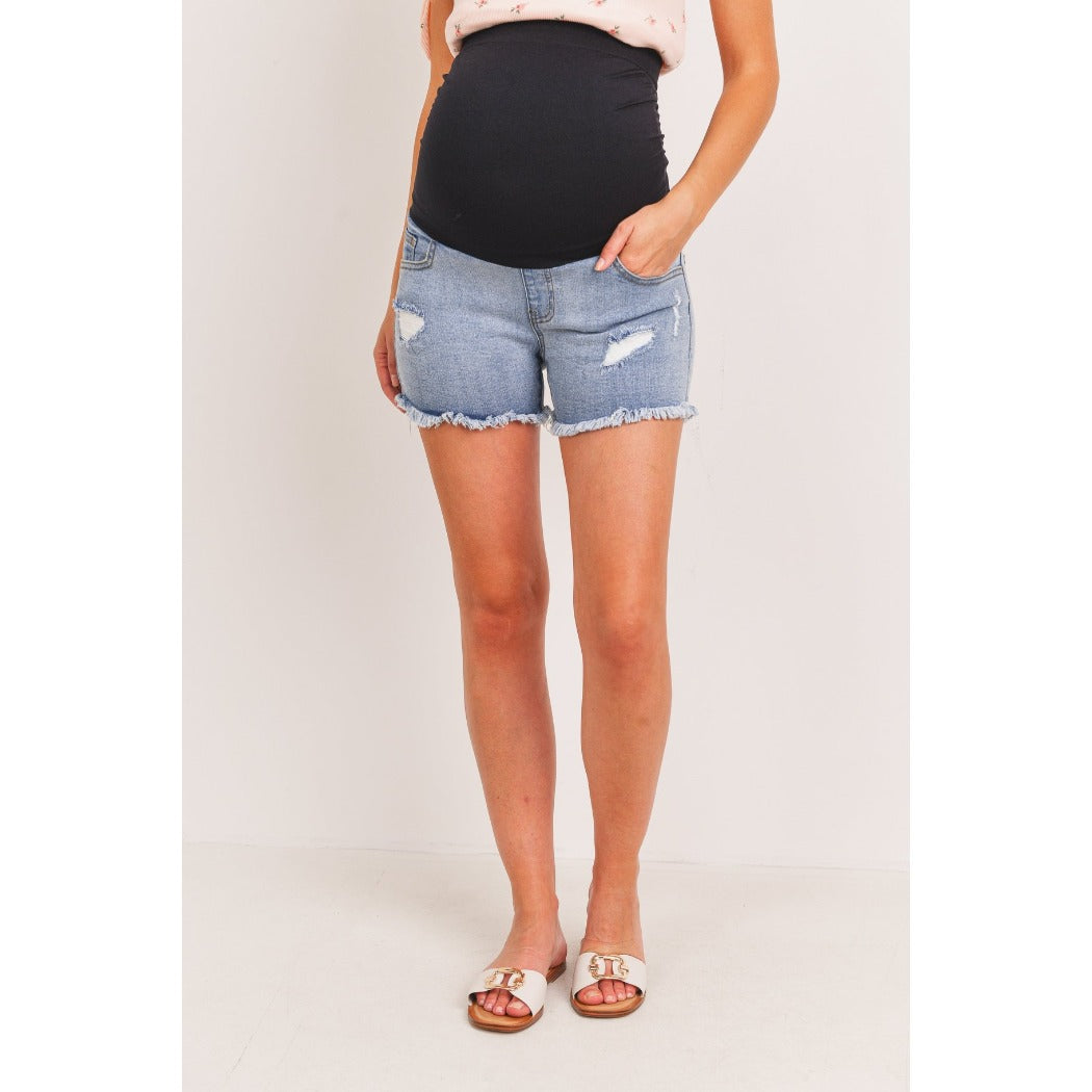 Maternity denim shorts, shown on a white woman wearing sandals.