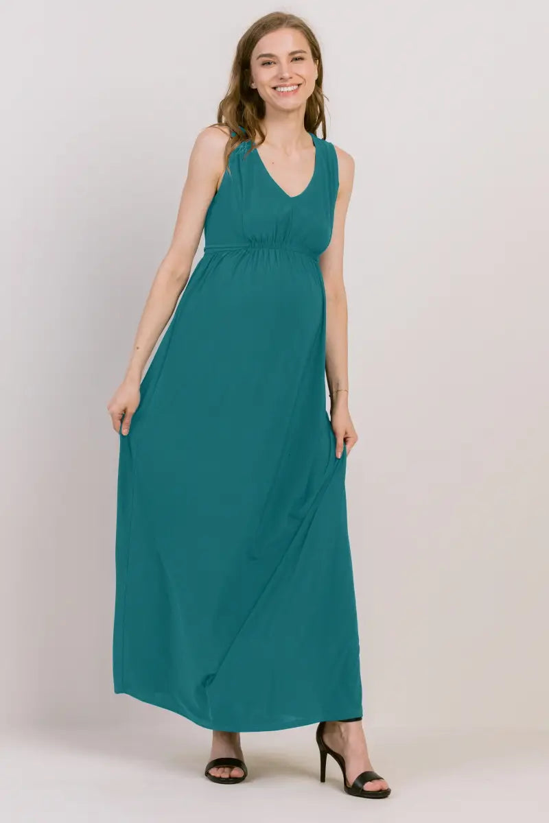 Pregnant woman in a long teal maternity dress